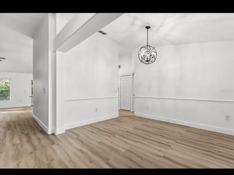 Dining room with hardwood floors and orb chandelier by JM Home Industries