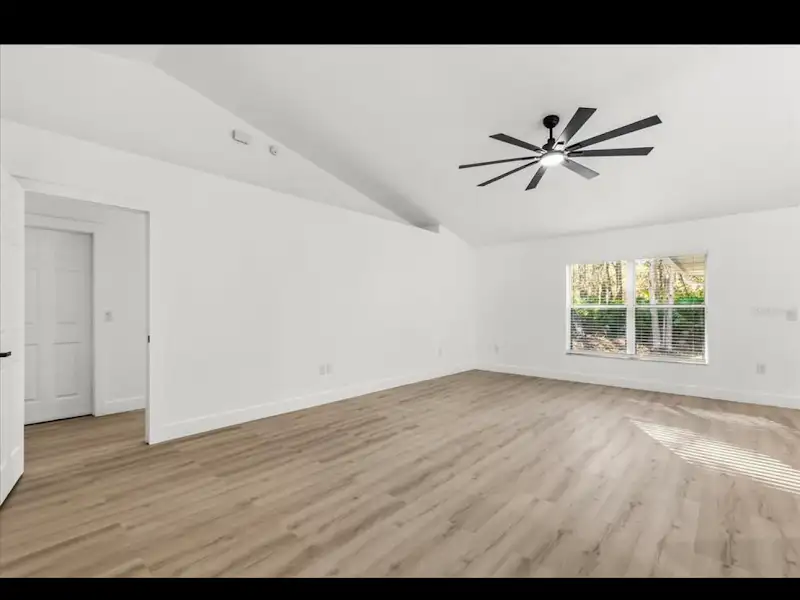 Master bedroom with modern ceiling fan and hardwood by JM Home Industries