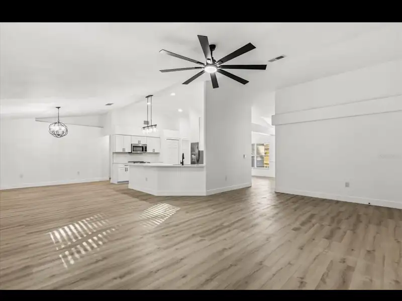 Open concept living room and kitchen with hardwood floors by JM Home Industries