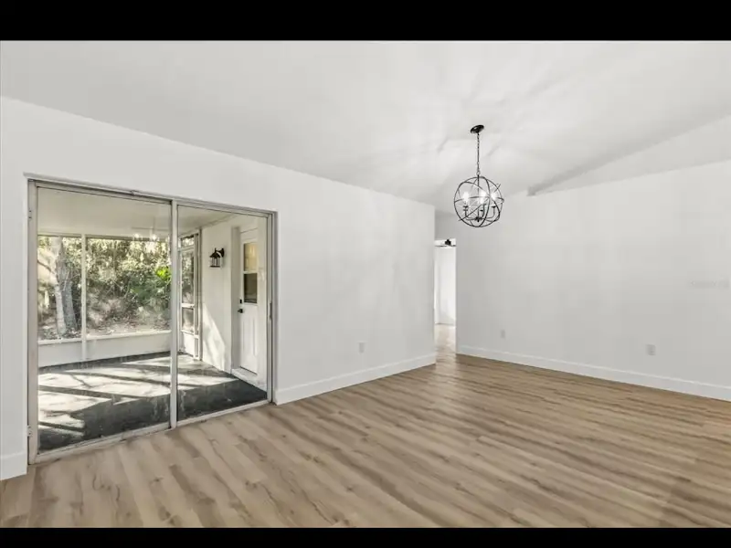 Room with sliding glass doors and chandelier by JM Home Industries