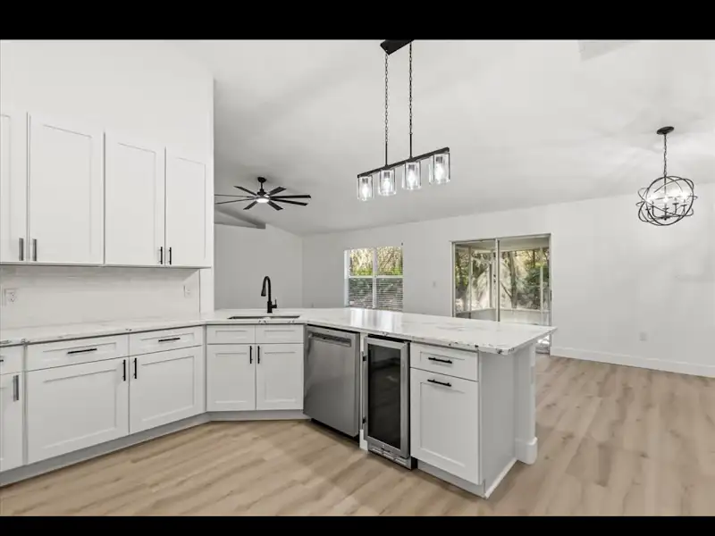 White kitchen with marble countertops by JM Home Industries