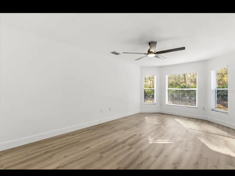 Bedroom with bay window and ceiling fan by JM Home Industries