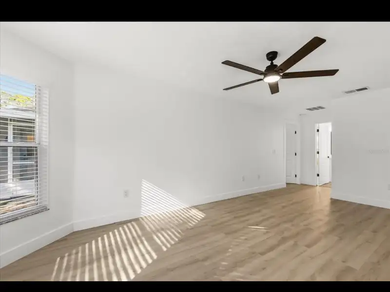 Bedroom with ceiling fan and hardwood floors by JM Home Industries